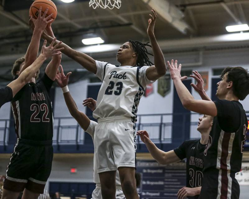 Oswego East's Mason Lockett IV (23) grabs a rebound during their basketball game between Plainfield North at Oswego East Friday, Dec 5, 2025 in Oswego.