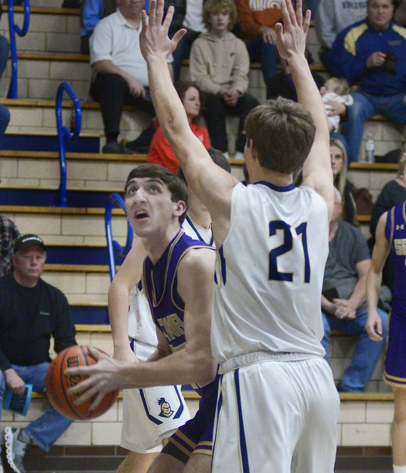 Serena’s Richie Amour eyes the basket as Marquette’s Charlie Mullen sets to block during the 1st period Tuesday at Marquette.