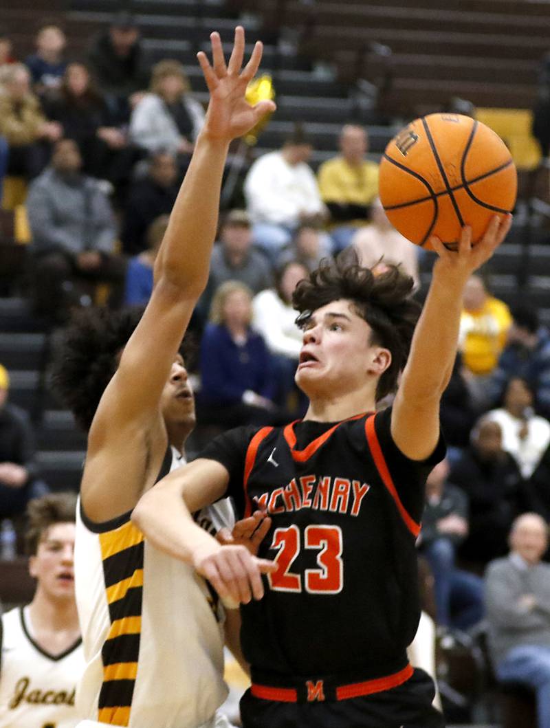 McHenry's Marko Stojich shoots the ball over the defense of Woodstock's Maxwell Beardj during a Fox Valley Conference basketball game on Friday, Jan. 24, 2025, at Jacobs' High School.