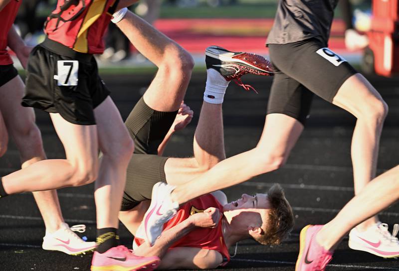 Batavia’s Colin Knowles rolls on the track after falling in the first few steps of the 1,600-meter run at the Les Hodge Boys Track and Field Invitational at Batavia High School on Friday, April 5, 2024.