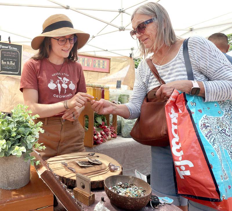Jen Gontarek, (left) from Genoa, owner of Gratefully Dreaming, talks to Mary Hamell, of DeKalb, about birthstone rings she is selling at her booth Thursday, June 2, 2022, during the first DeKalb Farmers Market of the season at Van Buer Plaza in Downtown DeKalb.