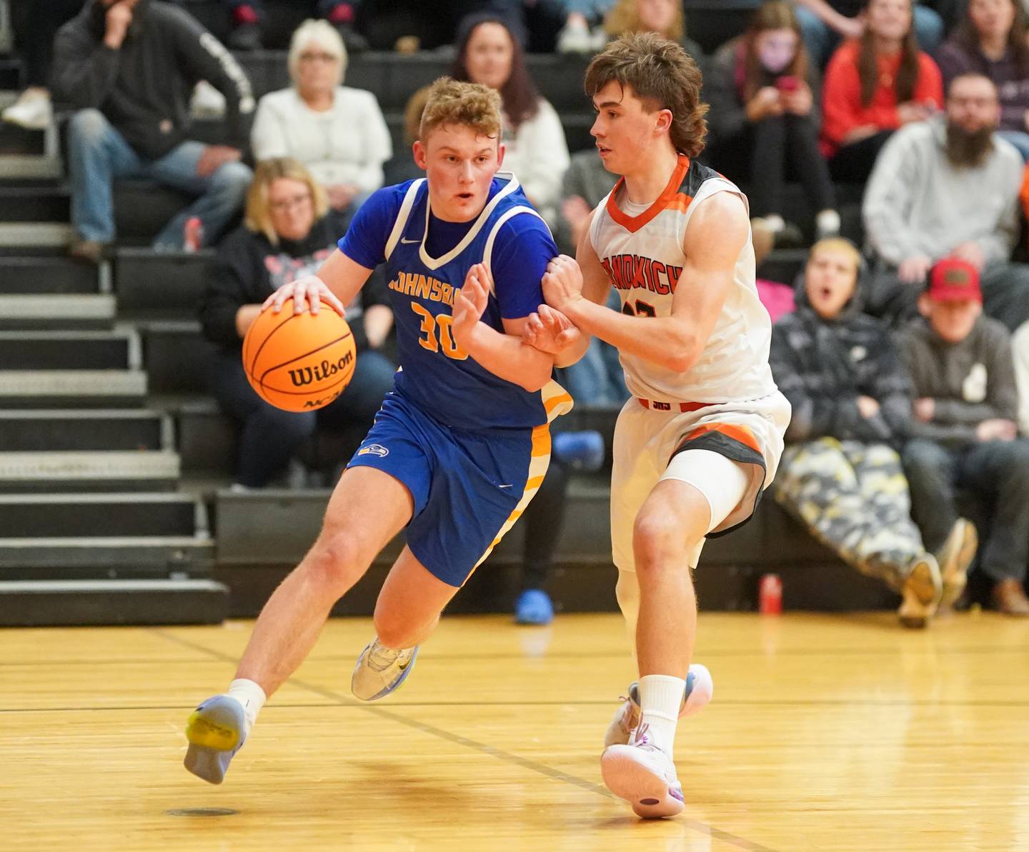 Johnsburg's Jayce Schmitt (30) drives the baseline against Sandwich’s Braden Behringer (12) during a basketball game at Sandwich High School on Friday, January 31, 2025.