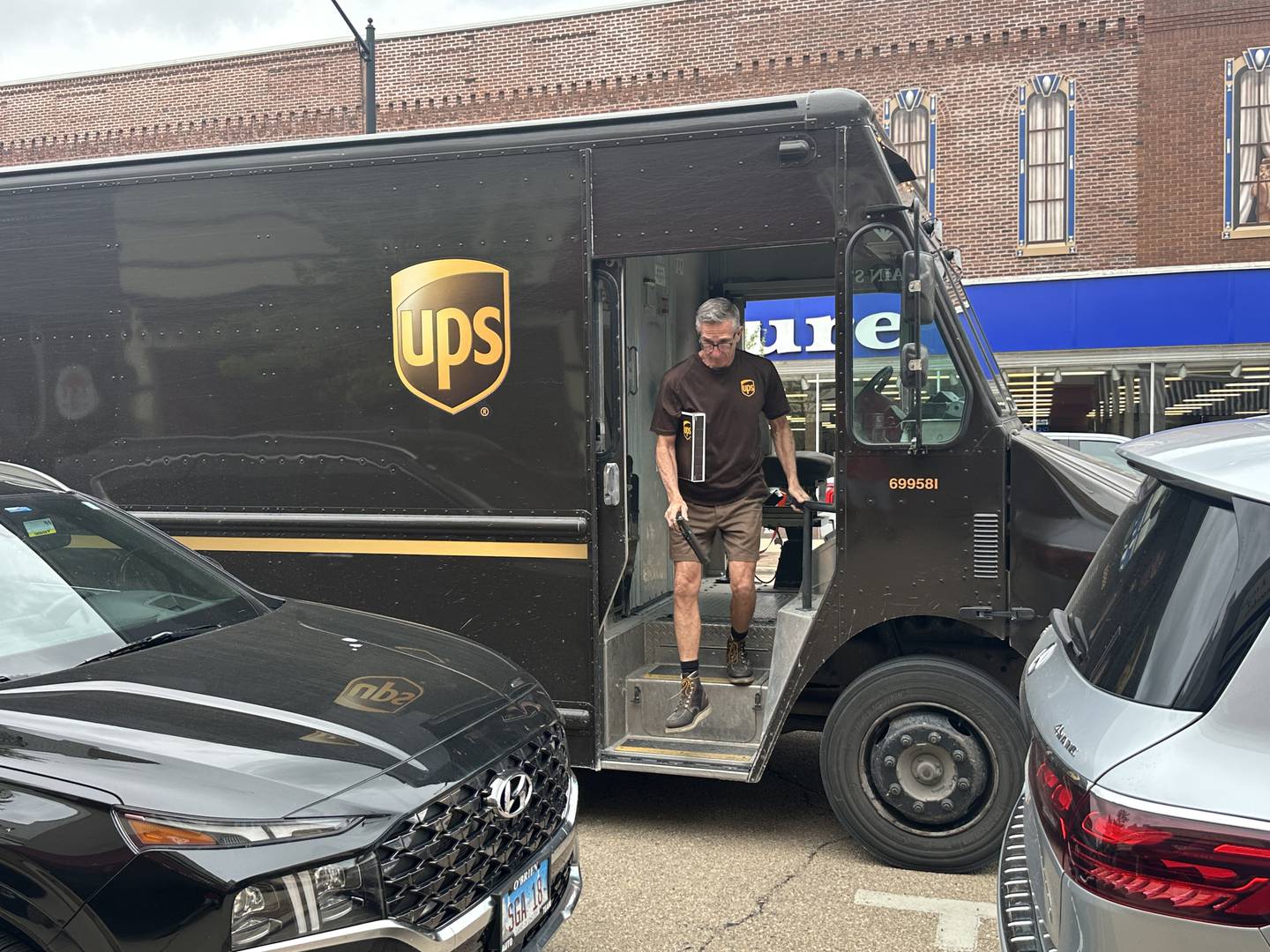 UPS driver Jim Bezley, steps out of his truck with a package during his final delivery on Friday, April 24, 2026 down Main Street in Streator. Bezley is retiring from UPS after 47 years. Bezley began working for UPS right out of high school in 1979.