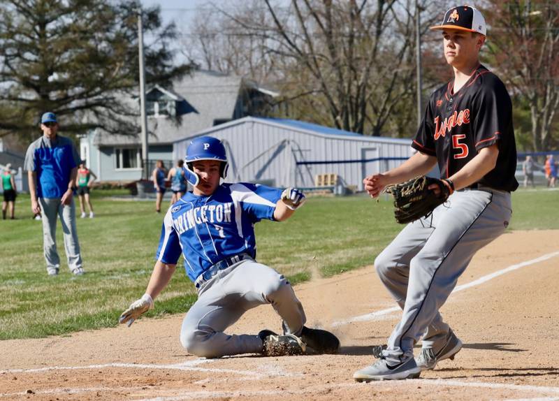 Princeton's Augie Christiansen slides into home on a wild pitch Tuesday against Kewanee.