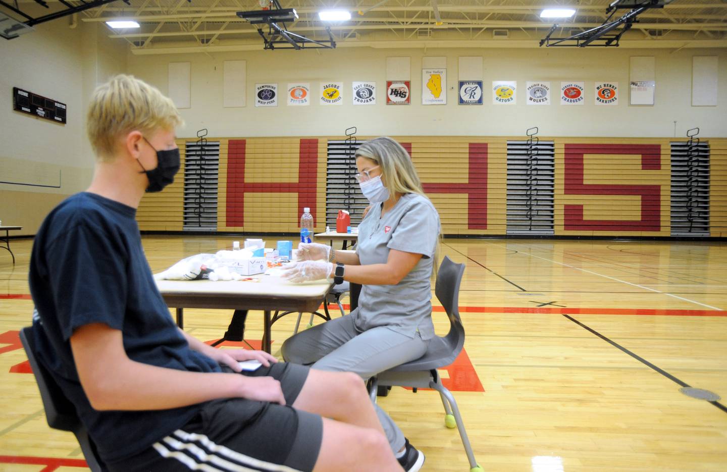 Ethan Robertson, 15, of Huntley, waits as pharmacist assistant Jacquelyn Potokar prepares to give Robertson a dose of the Pfizer Covid Vaccine Saturday morning, July 31, 2021, during a Walgreen’s Vaccination Clinic at Huntley High School.