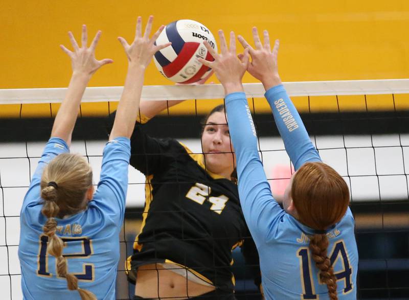 Putnam County's Maggie Richetta tries to squeeze a spike past Marquette's Lily Craig and teammate Maera Jimenez on Thursday, Sept 7, 2023 at Putnam County High School.