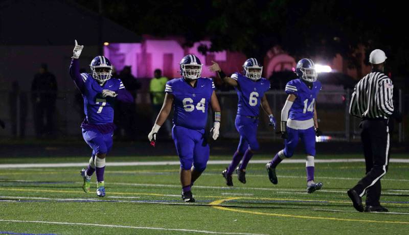 Larkin's Diyonnes King (7) Angel Gonzalez (64) Chevelle Clements (6) and Michael Bresnen (14) celebrate a turnover to get the ball back late in the fourth quarter against Elgin during the annual crosstown rival game at Memorial Field  Friday October 14, 2022 in Elgin.