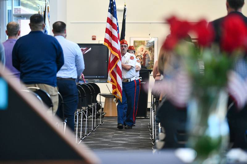 Joseph Mayfield, commandant of the Marine Corps League Detachment 1253, leads the group in the retrieval of the colors Thursday afternoon at the conclusion of the Kankakee Community College’s Veterans Day recognition event. A table of remembrance displays a folded flag and a vase of flowers in the foreground.