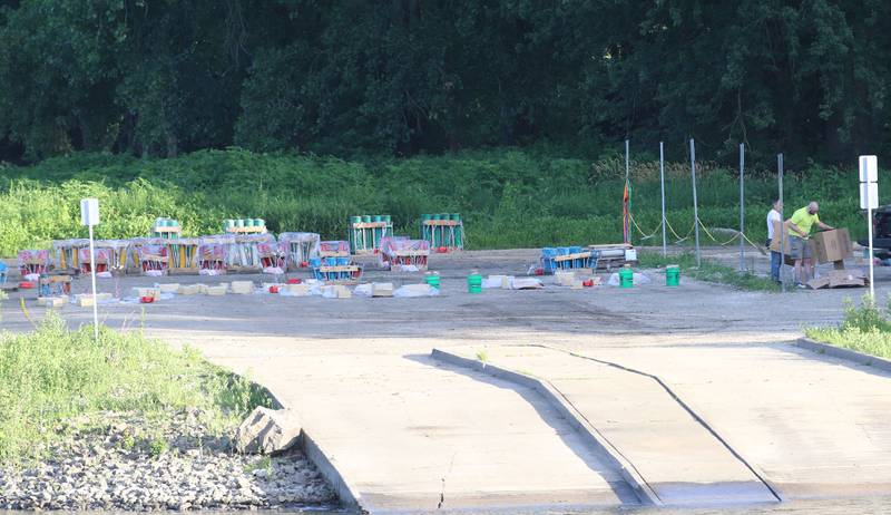 Pyrotechnics prepare the fireworks near the boat launch area across from Water Street along the Illinois River in Peru.