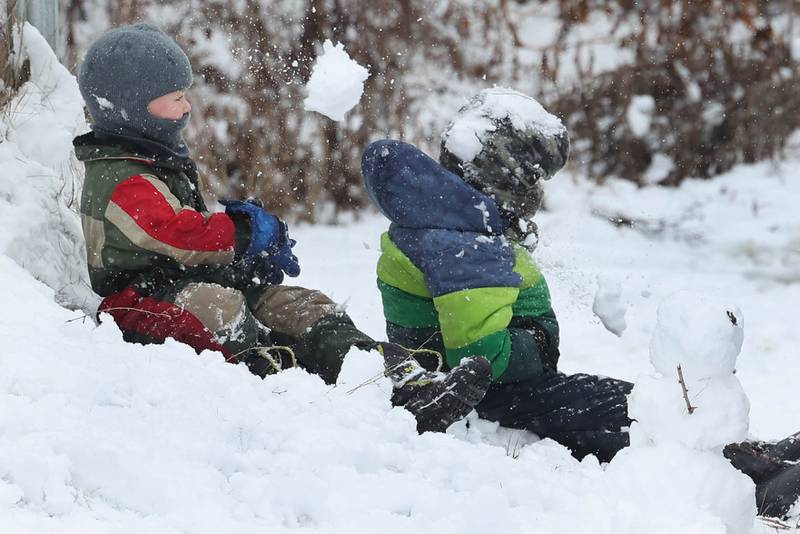 Isaiah Sutter, (left) 4, from DeKalb, gets his brother Josiah, 6, with a sneak attack snowball Wednesday, Jan. 25, 2023, at Hopkins Park in DeKalb.