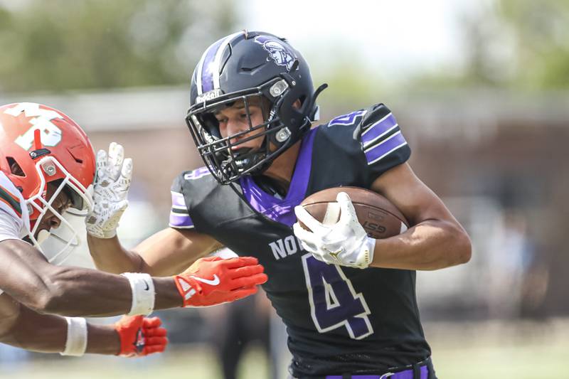 Downers Grove North's Caden Chiarelli (4) fights of a tackle attempt while running down the sidelines during football game between Downers Grove North at Morgan Park Saturday, Aug 30, 2025  in Chicago.