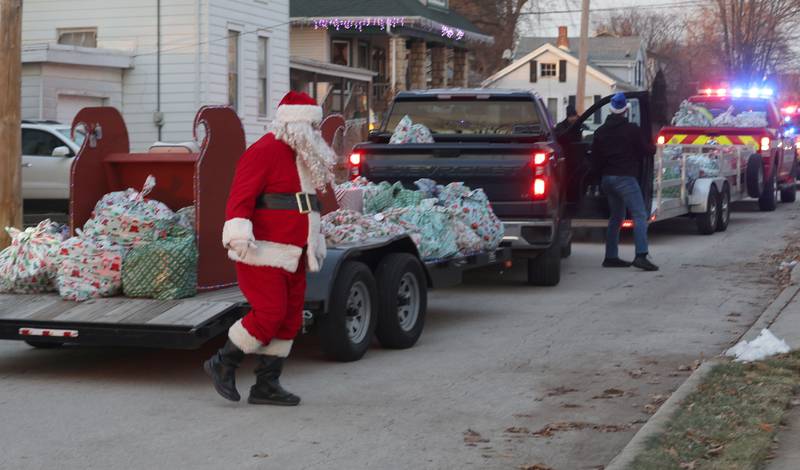 Santa delivers gifts near the intersection of 2nd and Calhoun Street as he delivers gifts to over 120 kids through the through Blue and Red Christmas for Kids on Friday, Dec. 19, 2025 in Peru. The Christmas program was established in 2013 by the Peru police and fire departments. It donates more than gifts to children in need.