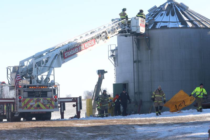 Emergency crews carry a rescue tube out of a grain bin rescue scene on Monday, Jan. 26, 2026 in the 13000 block of North 950th Avenue just south of Granville. Two lifeflight helicopters laned and one victim was flown from the scene.