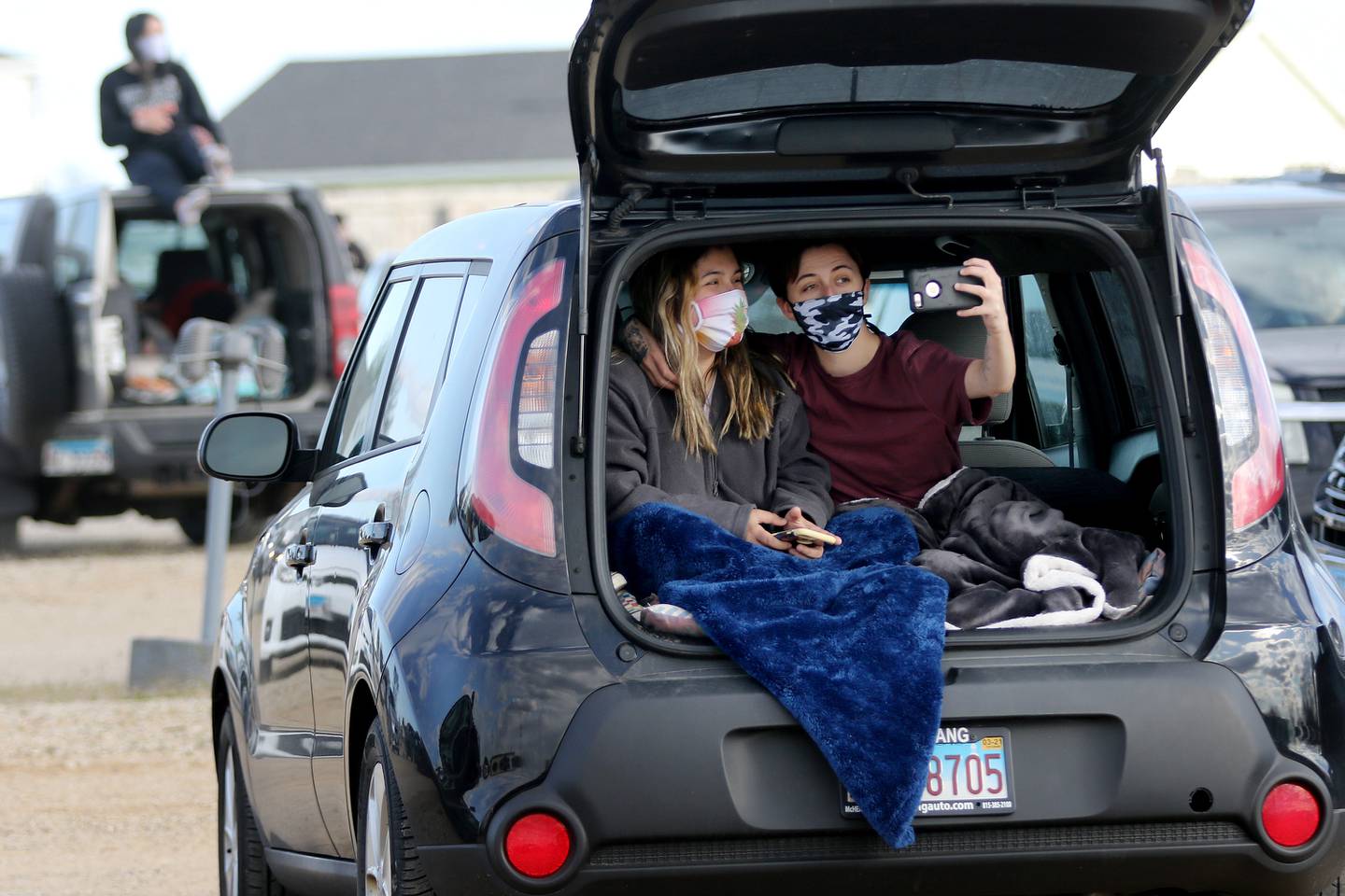 Katlin Shaw of Waukegan, right, takes a selfie with Natalie Balbuena of Round Lake, left, as they await the season opening night with showings of "The Flintstones" and "Jurassic Park" at the Golden Age Cinemas McHenry Outdoor Theater on Friday, May 8, 2020, in McHenry.