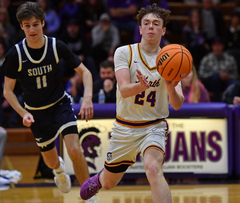 Downers Grove North’s Owen O'Reilly (24) passes as Downers Grove South’s Sean Day defends during a game on December 20, 2025 at Downers Grove North High School in Downers Grove.