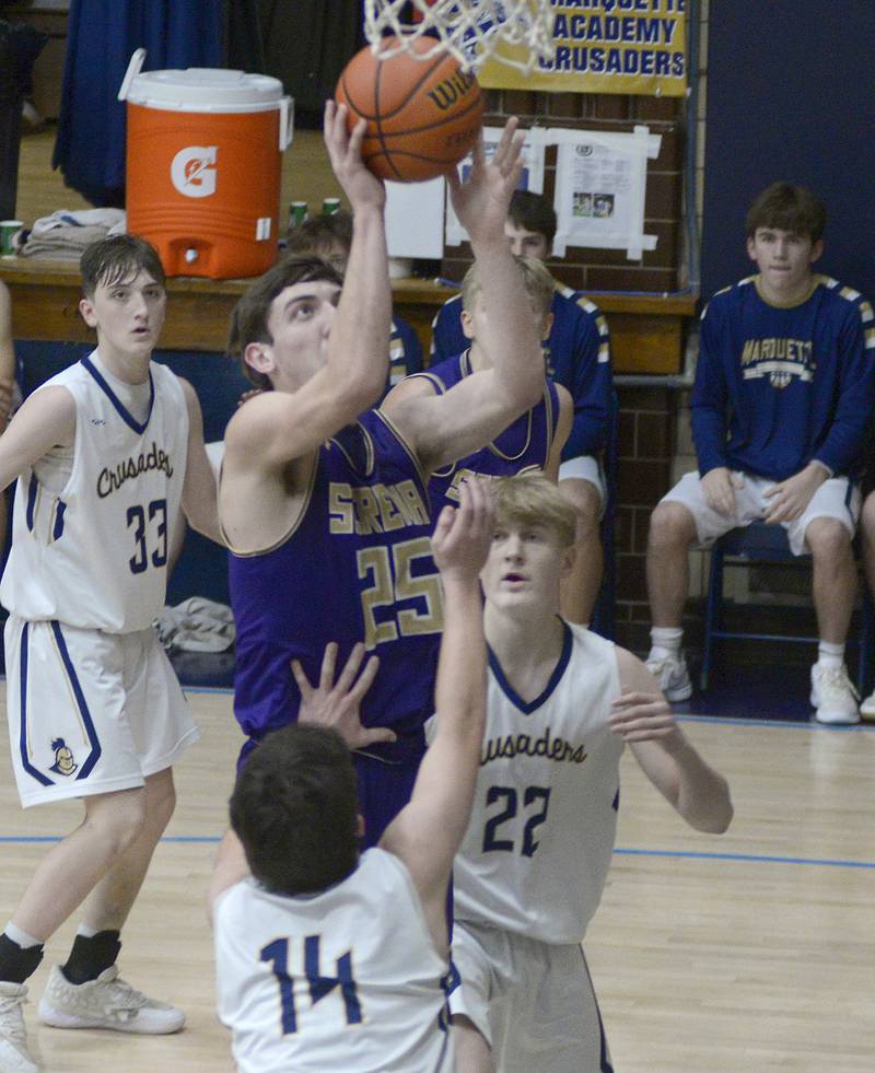 Serena’s Richie Amour sets to layup between Marquette’s Carson Zellers and Henry McGrath  during the 2nd period Tuesday at Marquette.