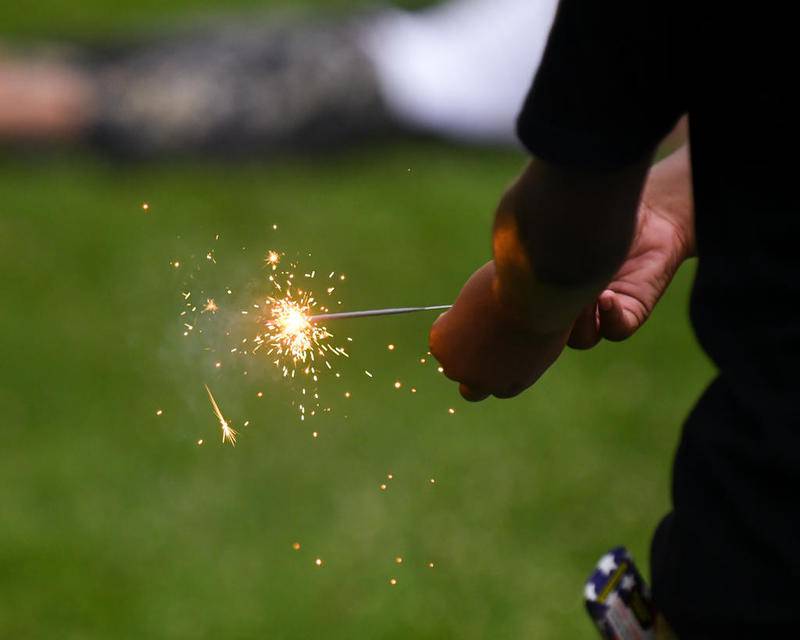 A young boy plays with a sparkler before the fireworks display Wednesday at Hopkins Park in DeKalb.