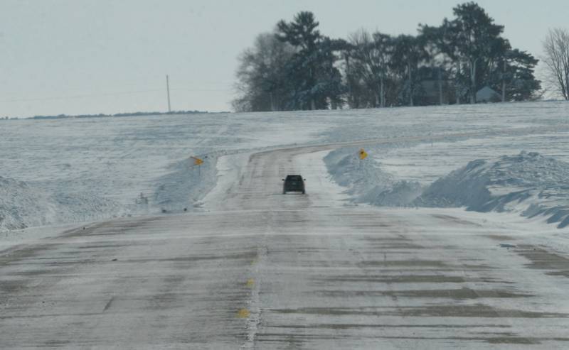 A lone vehicle makes its way south over packed ice and snow on state Route 26 between Forreston and Polo on Monday, Jan. 15, 2024 as temperatures remained below zero throughout the day.