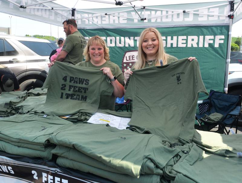 Lori Miller and Devon Gugerty of the Lee County Sheriff's Department hold up shirts that are being sold to help cover costs for the department's two K9 program. The sheriff's department had a booth at Discover Dixon's Sizzling Summer Block Party at the Plaza North Shopping Center in Dixon on Saturday, June 10. Shirts will also be available at Dixon City Market on June 14 and at other upcoming community events.