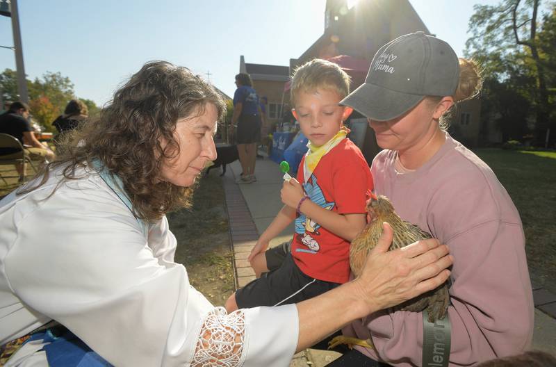 Geneva Lutheran ChurchÕs Pastor Trudy Stoffel blesses a chicken named ÒOllyÓ as his pet family Greyson Lee, 6 and Taylor Lee of St. Charles look on during the churchÕs annual pet blessing service on Saturday, Oct 4, 2025 in Geneva.