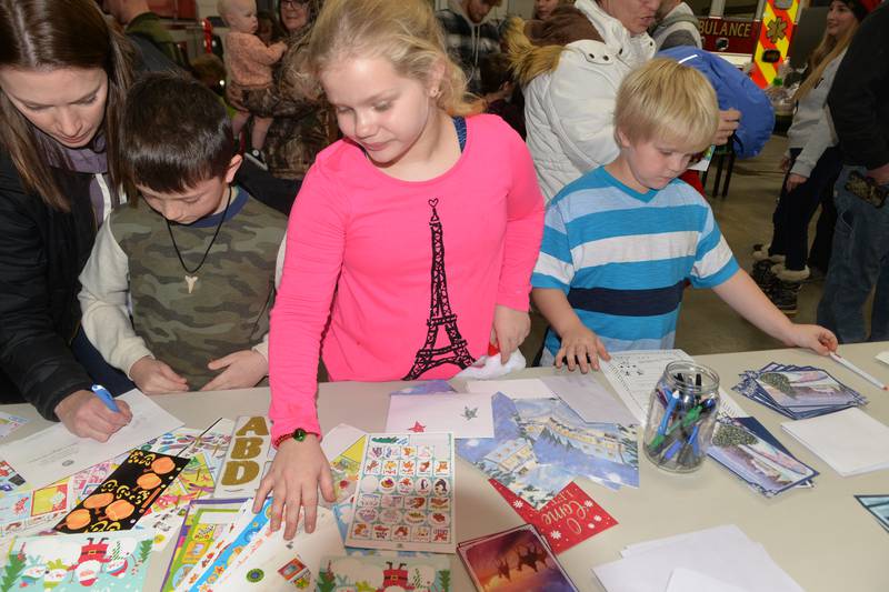 Reed Stichler, 7, of Erie, and Mia and Lucas Keller, 9 and 6, work on their letters to Sant during Erie's Hometown Holidays on Saturday, Dec. 2, 2023 at the Erie Fire Station.