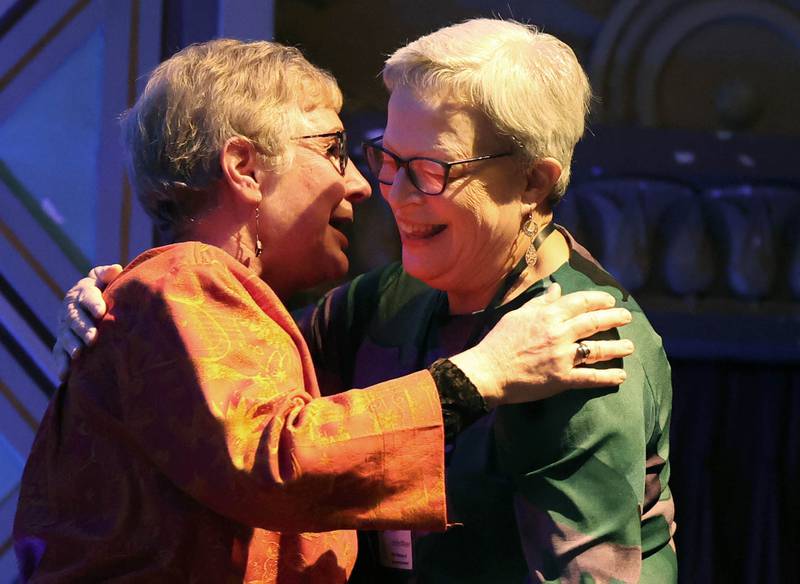 Jan VanderMeer, (right) retired from Northern Illinois University, gets a hug as she is announced as this year’s Woman of Accomplishment Honoree Thursday, Oct. 10, 2024, during the Athena and Women of Accomplishment Awards reception hosted by the DeKalb Chamber of Commerce at the Egyptian Theatre.