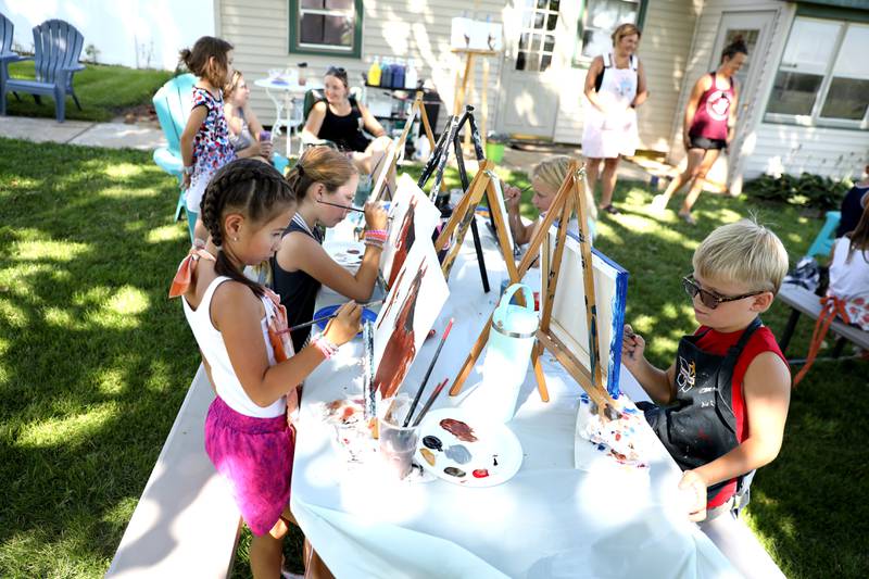 Young artists paint on canvas during a painting class with Chelsea McGhee Studios at the Little Cottage on the Farm in Kaneville on Thursday, July 27, 2023.