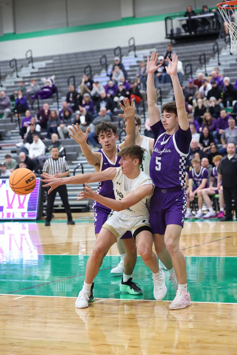 Bishop McNamara's Coen Demack passes away from Wilmington's Declan Moran, right, and Hunter Kaitschuck during Bishop McNamara's 61-24 victory over Wilmington in the IHSA Class 2A Seneca Sectional semifinal on Tuesday, March 3, 2026.