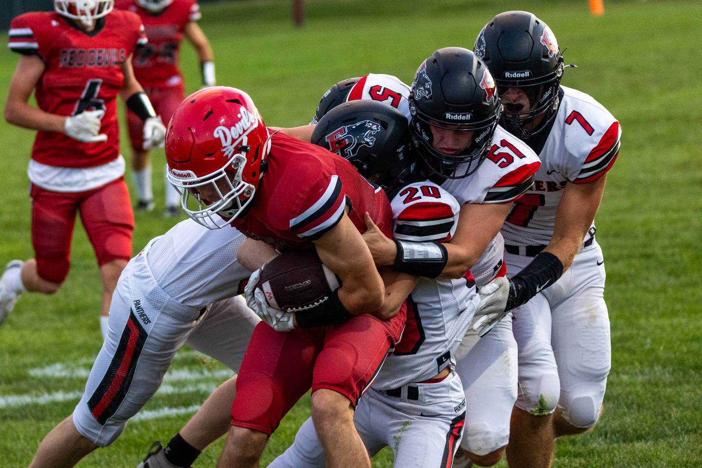 (from left) Braden Curran (8) of Hall is brought down by Erie-Prophetstown defense consisting of Lane Decker (20), Derek Naftzger (51) and Gaven Adams (7) on Friday, Sept 5, 2025 at Richard Nesti Stadium in Spring Valley.