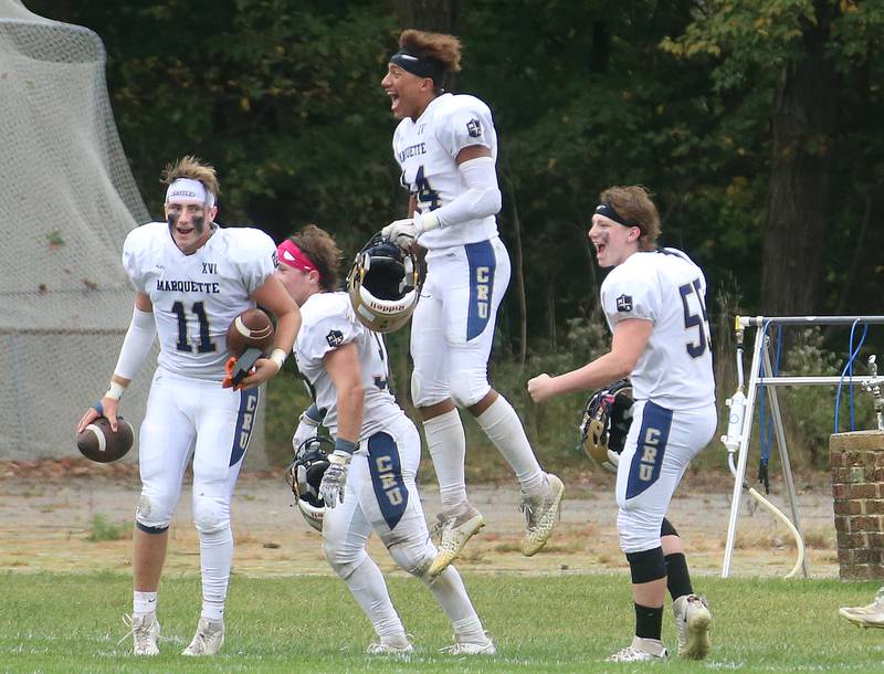 Marquette players Anthony Couch, Grand Dose, Marcus Baker and Sean Kath celebrate on the sidelines after scoring a touchdown against St. Bede on Saturday, Sept. 28, 2024 at St. Bede Academy.