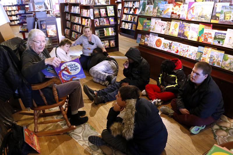 Bette Chwalisz, a retired teacher, reads a book on Thursday, Feb, 20, 2025, at Read Between The Lynes in Woodstock as students in a life skills class at Menta Academy Woodstock listen to the story during the bookshop's weekly story time.