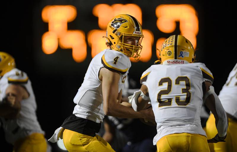 Carmel’s Johnny Weber fakes a handoff to Donovan Dey in a football game against St. Viator in Arlington Heights on Friday, September 16, 2022.