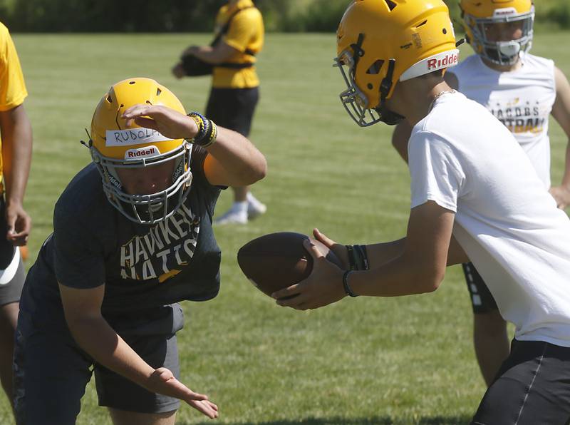 Paulie Rudolph receives hand-off from quarterback Max Benner during football practice Monday, June 20, 2022, at Jacobs High School in Algonquin.