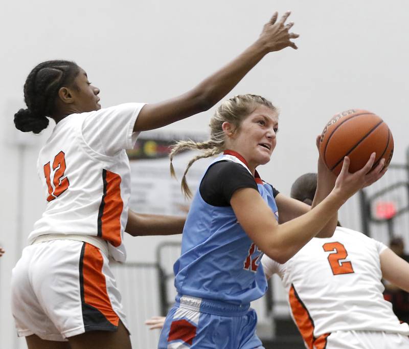 Marian Central's Madison Kenyon drives to the basket against DeKalb’s Brytasi Long during a Northern Illinois Holiday Classic girls semifinal basketball game Tuesday, Dec. 19. 2023, at McHenry High School.