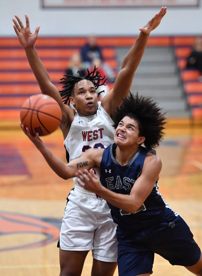Oswego East's Drey Wisdom goes to the basket in front of West AuroraÕs Andrew Wiggins during a Hoops for Healing tournament game on Nov. 20, 2023 at Naperville North High School in Naperville.