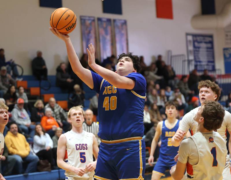Aurora Central Catholic's Braden Dillon shots a layup over Genoa-Kingston's Kash Sunderlage Monday, Feb. 23, 2026, during their IHSA Class 2A regional quarterfinal at Genoa-Kingston High School.