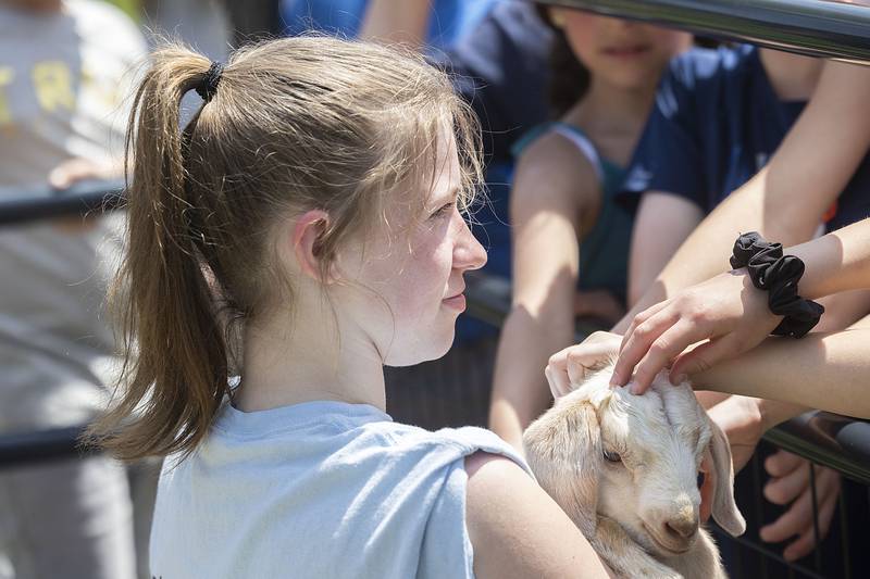 Sterling High School freshman Grace Wetzell holds a one-week-old baby goat for visitors Thursday, May 11, 2023 during Farmapalooza.