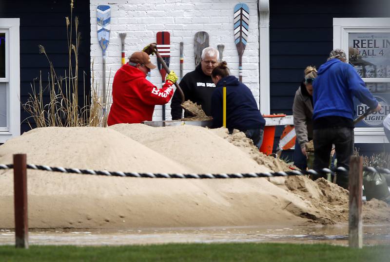 People fill sandbags near the Bru Crew Bar and Grill on Sunday, April 19, 2026, in Johnsburg as the Fox River continues to rise.