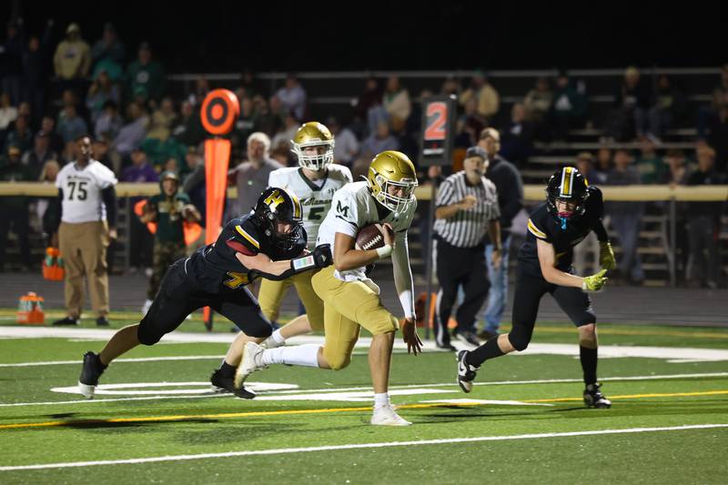 Bishop McNamara's Karter Krutsinger pulls away from Herscher's Jaxon Sukley en route to a touchdown during the Fightin' Irish's 45-28 victory over the Tigers on Friday, Sept. 5, 2025.