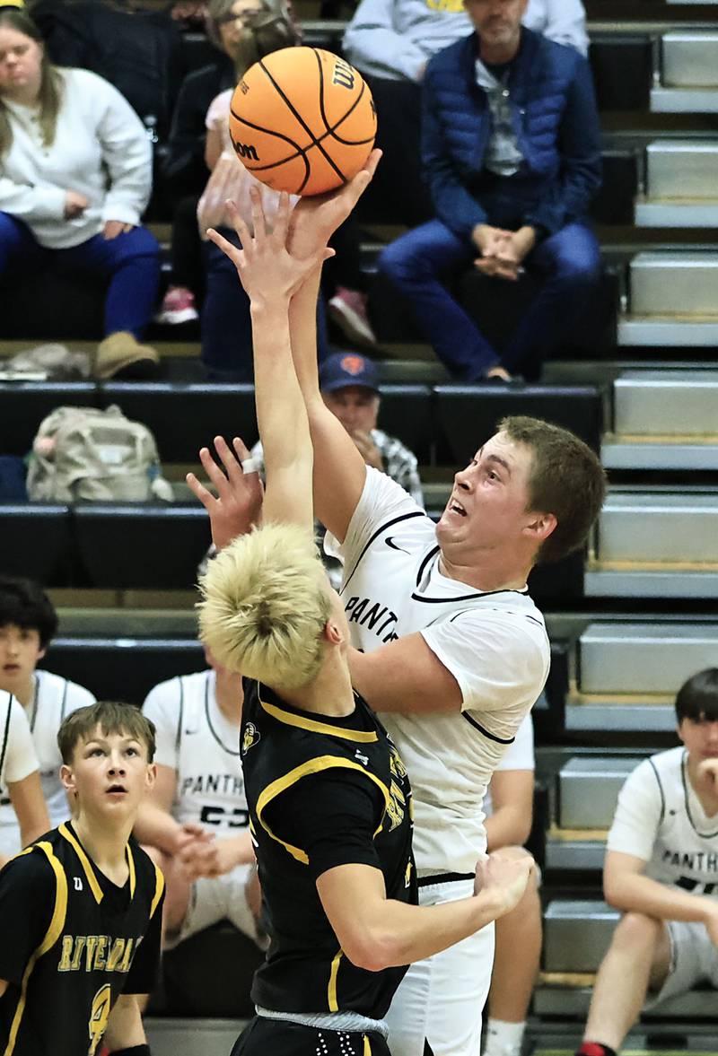 E-P’s Evan Steimle shoots over the Riverdale’s Jackson Tegeler Friday night in Prophetstown.