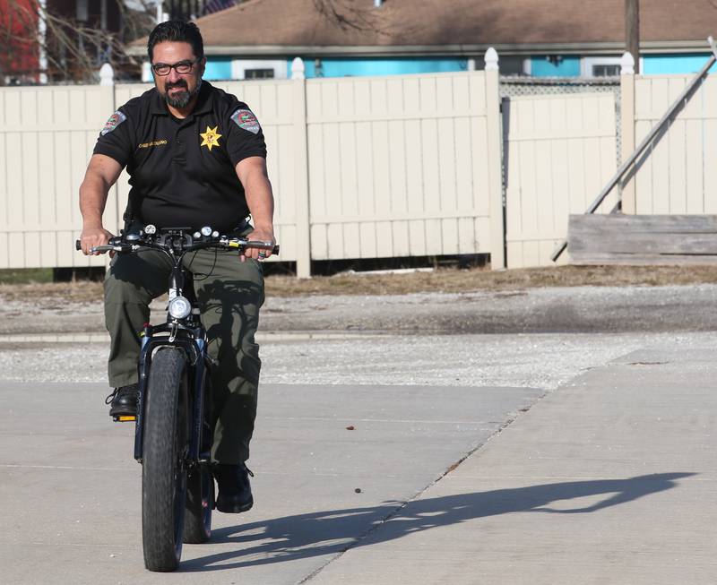 Utica Police Chief James Mandujano rides the departments police bike in the parking lot of the Utica Police Station on Wednesday, Dec. 20, 2023 in Utica. Under a new law taking effect Jan. 1, 2024, the definition of an "authorized emergency vehicle" is expanded to include any vehicle designated for police usage, including all-terrain vehicles and bikes.