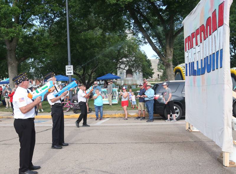 The Princeton Veterans & Color Guard use squirt guns to spray colors on a "Freedom" sign before the Arukah Institute of Healing Freedom Color Run on Friday, July 4, 2025 at Soldiers and Sailors Park in Princeton.
