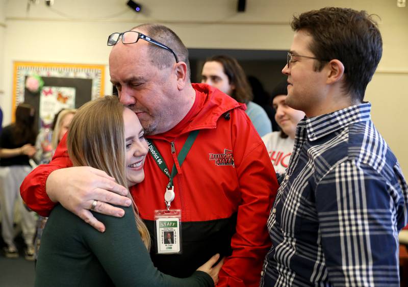 Prairieview Elementary School Principal Mark Pagel (center) embraces his daughter, Marissa Bessler, as her husband, Josh, looks on after Pagel was surprised as Illinois Principals Association Principal of the Year at the Downers Grove school on Wednesday, March 9, 2022. Prairieview is part of Center Cass School District 66.