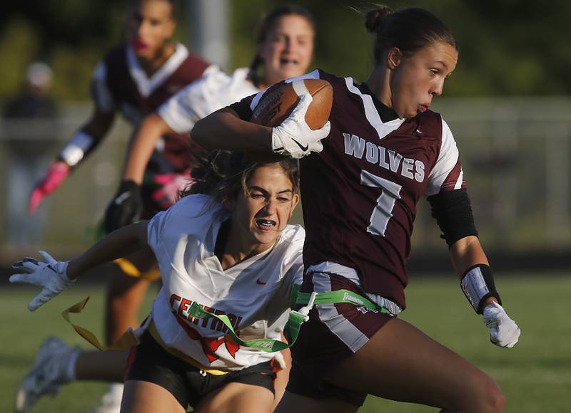 Prairie Ridge’s Lila Stewart runs with the ball as Crystal Lake Central's Colbie Donelson tries to grab her flag during a girls flag football game on Thursday, Sept. 4, 2025, at Prairie Ridge High School in Crystal Lake.