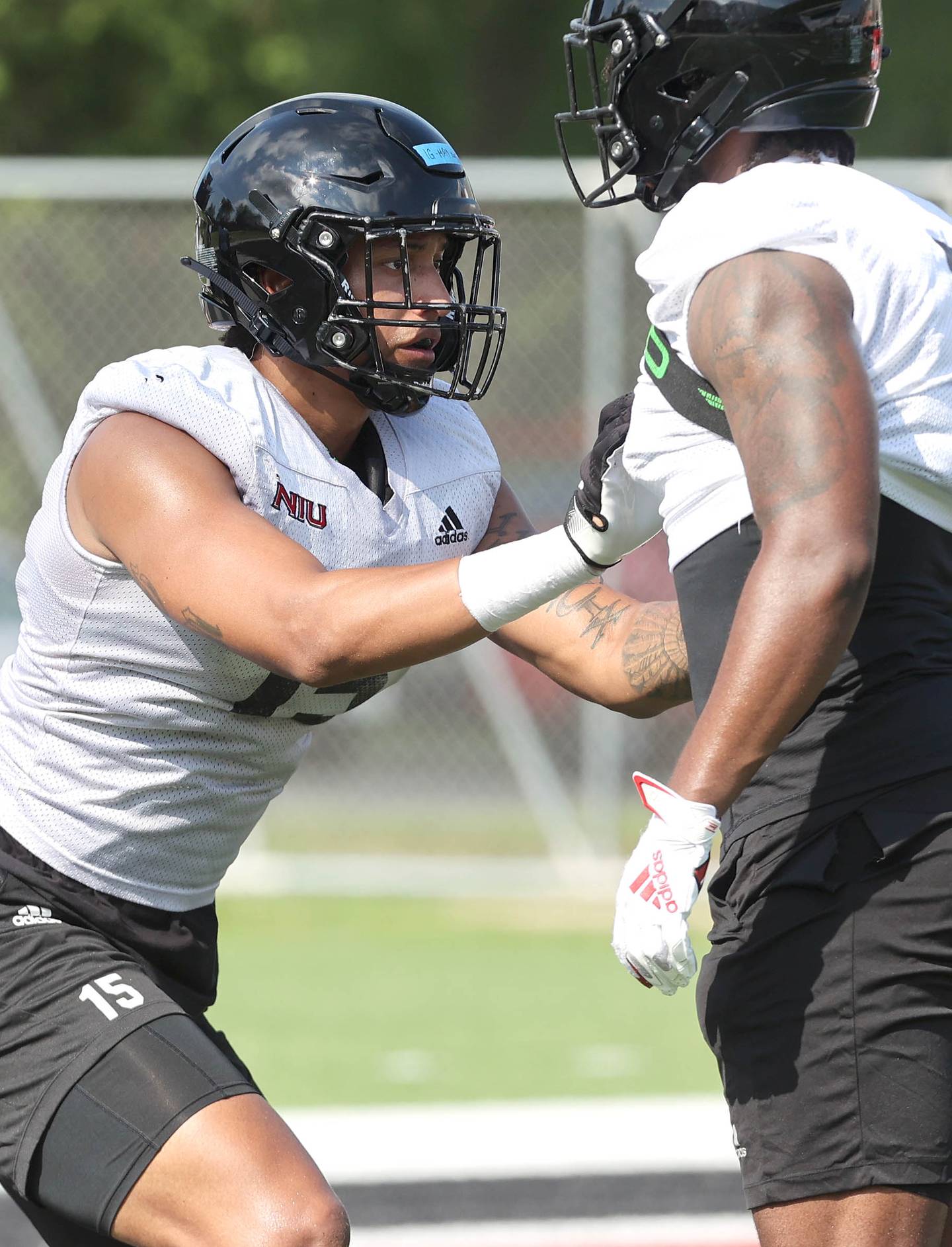 Northern Illinois University defensive ends Izayah Green-May (left) and Michael Kennedy take part in a drill Monday, August 1, 2022, during practice at Huskie Stadium in DeKalb.