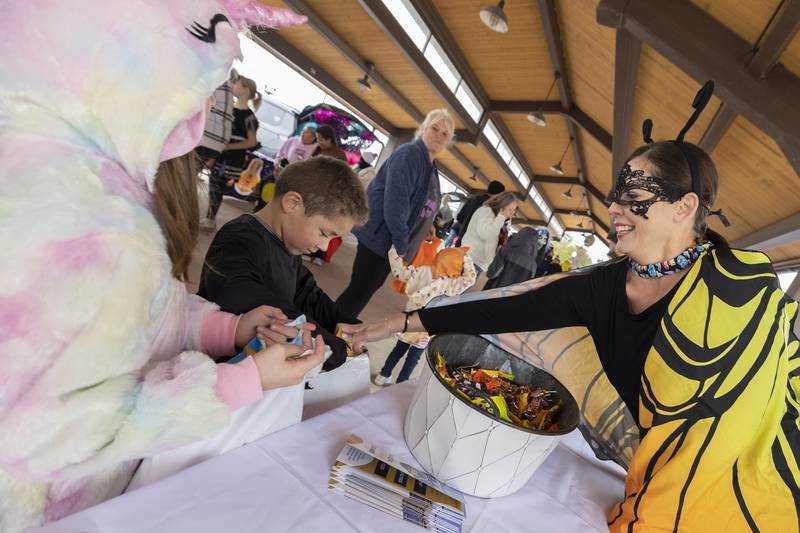 Dressed as a butterfly Angie Schneider hands out candy Tuesday, Oct. 28, 2025, during Sterling Police Department’s annual trunk-or-treat.