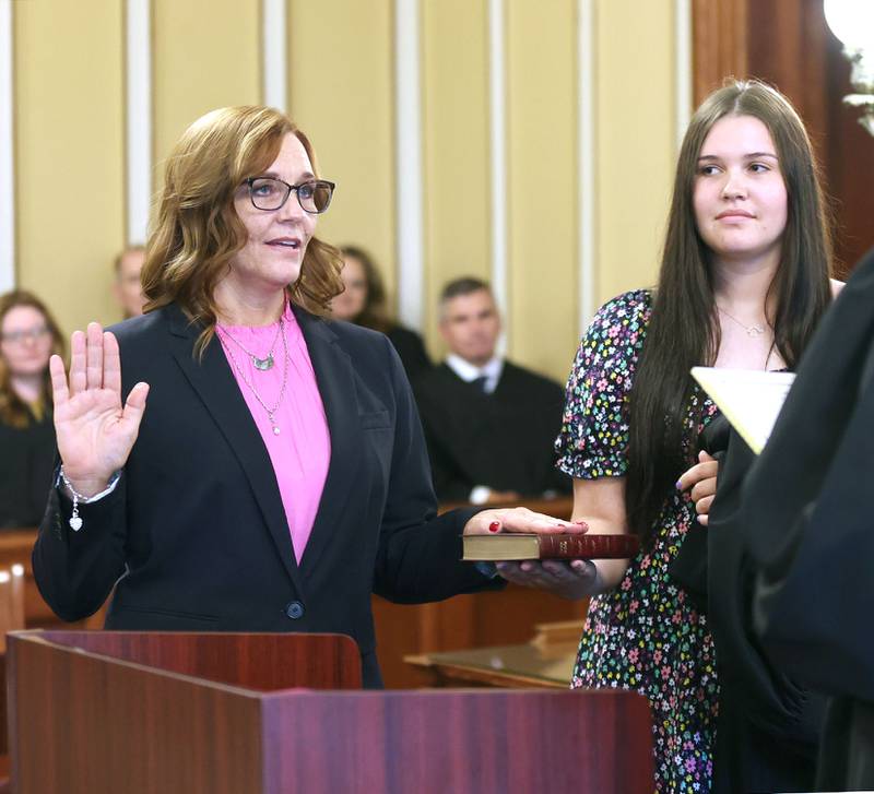 Jill K. Konen is sworn in as an associate judge of the 23rd Judicial Circuit Court by Chief Judge Bradley Waller of the 23rd Judicial Circuit as her daughter Amelia Konen holds the bible Friday, Sept. 23, 2022, at the DeKalb County Courthouse in Sycamore.