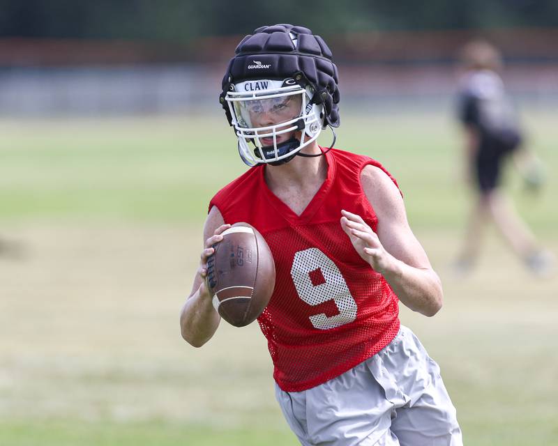 Dillon Griffin rolls out during passing drills at Oswego High School Football Practice, Monday, Aug 11, 2025  in Oswego.