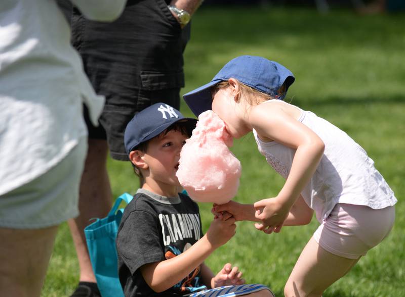 Logan and Olivia Cremibay of Downers Grove share cotton candy during the Downers Grove Park District's 75th anniversary party at McCollum Park Saturday, May 14, 2022.