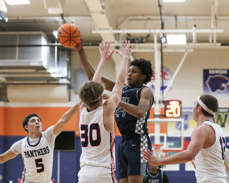Oswego East's Dshaun Bolden (24) passes to the corner on a drive down the lane during their basketball game between Oswego East at Oswego Friday, Jan 09, 2025 in Oswego.